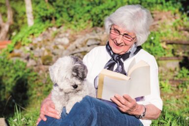 dame tenant un livre avec son chien