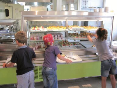 photo du self service du restaurant scolaire avec trois enfants en train de se servir