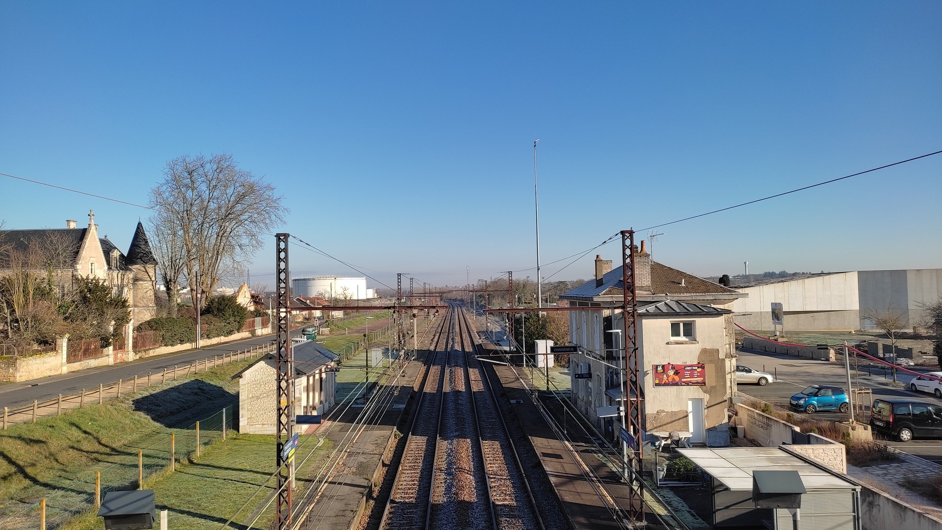vue de la voie ferrée en surplomb des voies avec la gare du bourg sur la droite