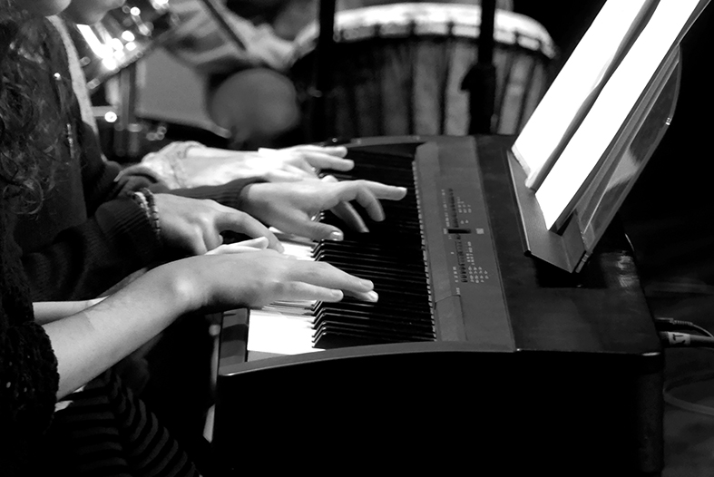 gros plan sur les mains de joueurs de piano avec un piano. photo en N/B