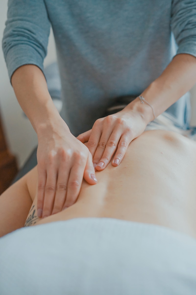 Un kinésithérapeute massant le dos d'un patient