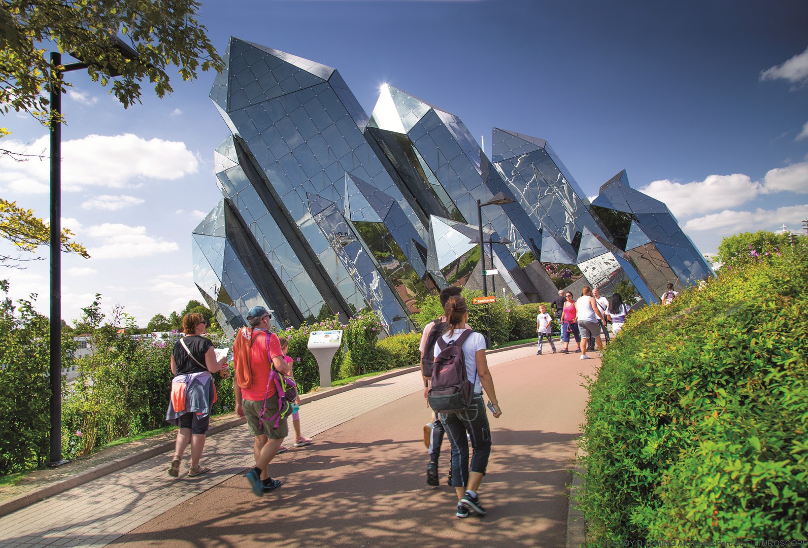 Vue sur le kinéma, une attraction du parc du Futuroscope. Des visiteurs sont en balade au premier plan