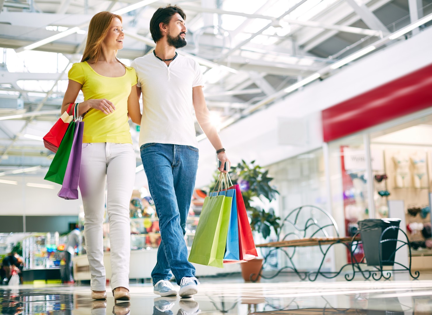 un homme et une femme déambulent dans une galerie marchande