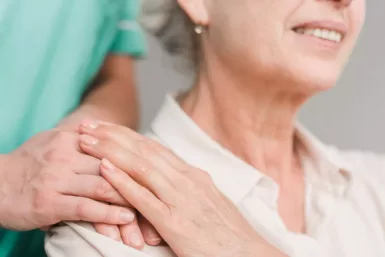 photo pour ADMR personne agées avec soignant gros plan main épaule