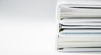 Une pile de comptes rendus épais sur une surface blanche