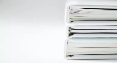 Une pile de comptes rendus épais sur une surface blanche