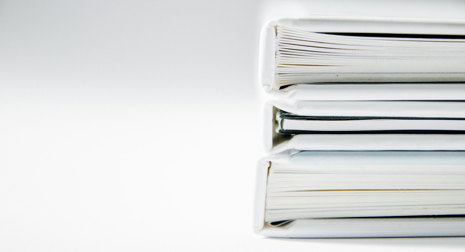 Une pile de comptes rendus épais sur une surface blanche