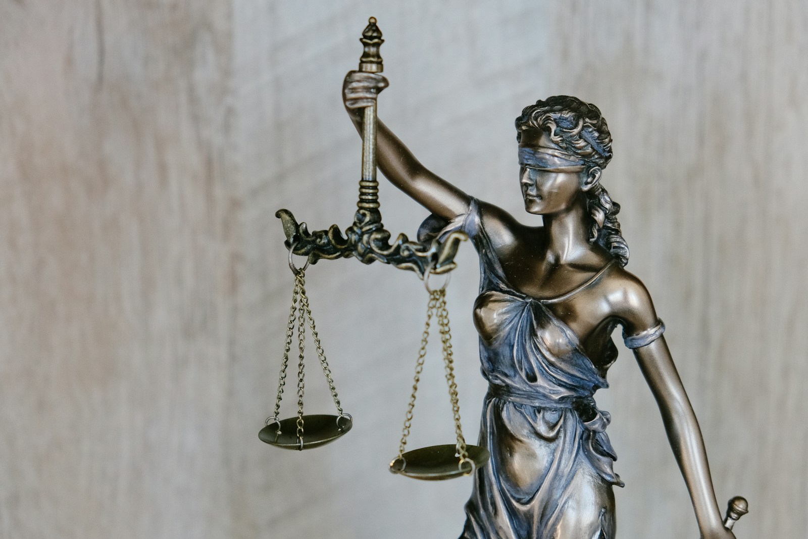 Statue d’une femme tenant une épée, en plein jour représentant la loi et la réglementation