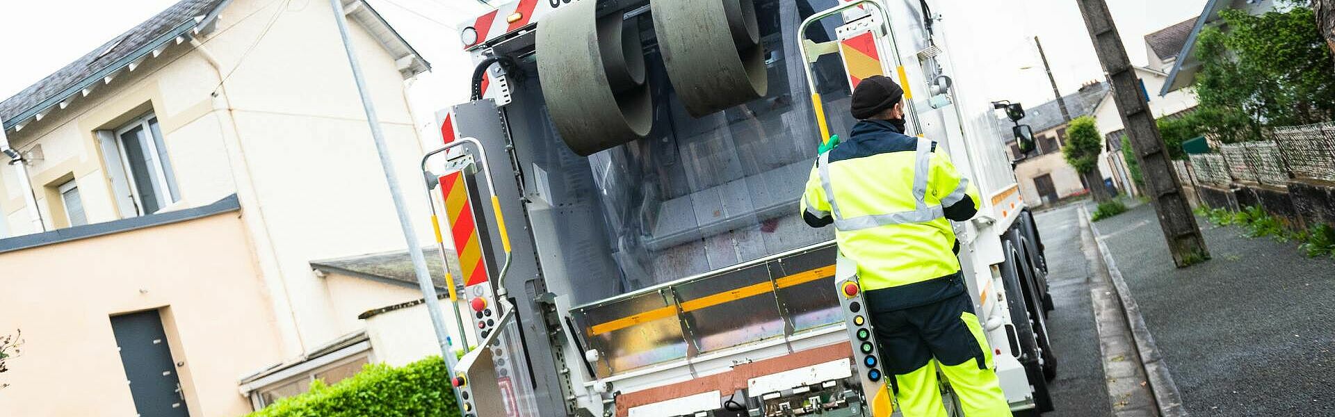 Camion poubelle dans une rue avec un agent collectant des déchets - Report de collecte