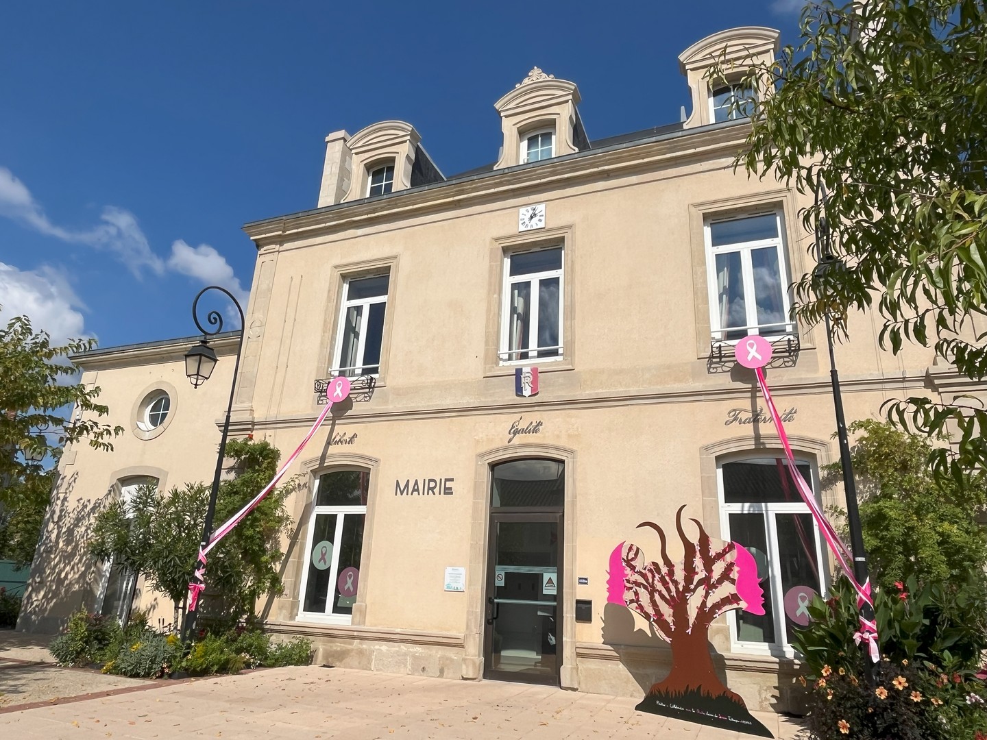 Photo de la façade de la mairie avec l'arbre réalisé par les jeune des Chantiers loisirs pour octobre rose
