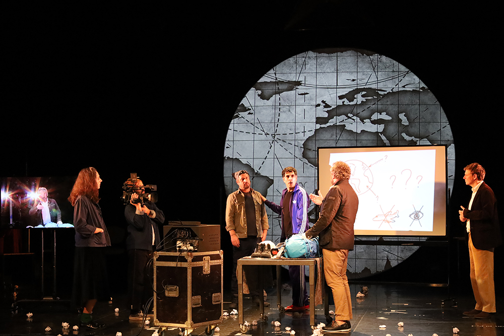 La montagne cachée (Les Dramaticules) Les comédiens sont sur scène, ils sont devant un grand planisphère et sont filmés et interviewés par des journalistes